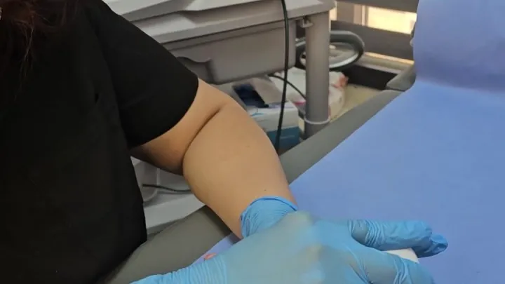 أخصائية علاج طبيعي تعمل يدوياً على ساعد المريض داخل غرفة العلاج